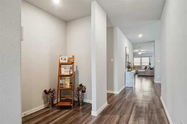 a view of a hallway with wooden floor and furniture