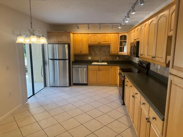 a kitchen with stainless steel appliances granite countertop a refrigerator and a sink