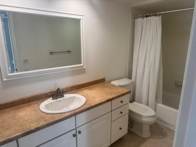 a bathroom with a granite countertop sink toilet and a mirror