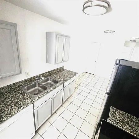 a kitchen with a stove and a white cabinet