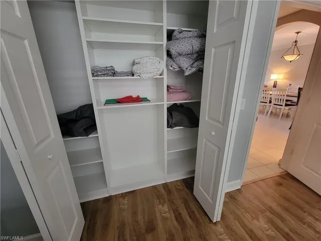 a view of walk in closet with clothes and shoes