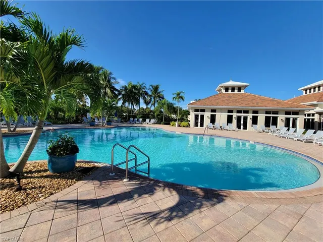 a view of a house with backyard sitting area and swimming pool