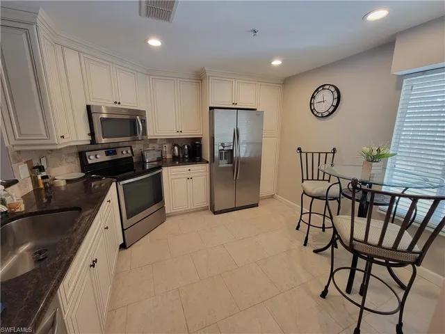 a kitchen with stainless steel appliances granite countertop a refrigerator and a stove top oven