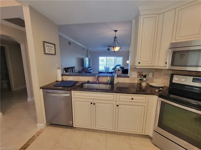 a kitchen with stainless steel appliances granite countertop a sink and a stove