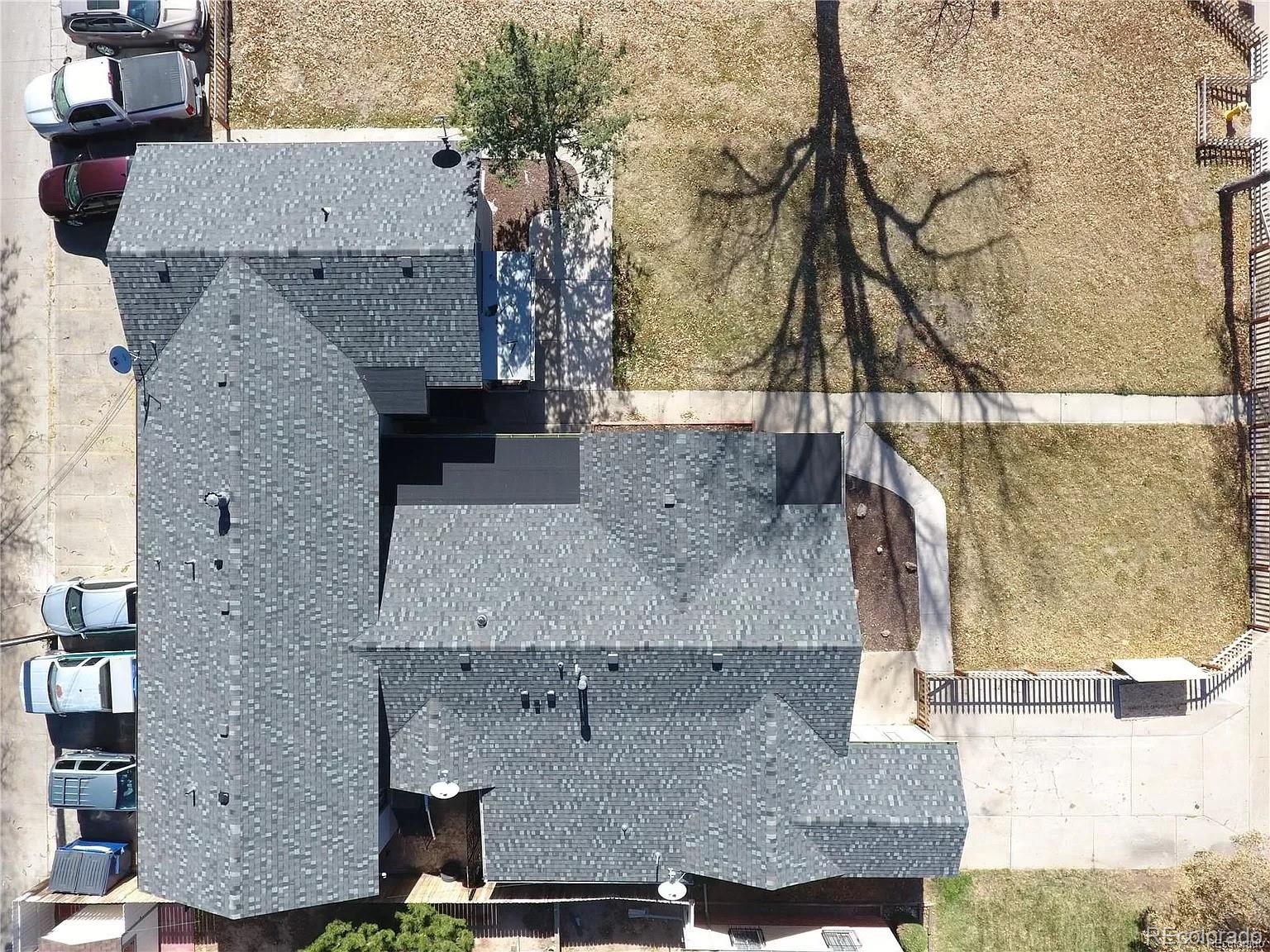 an aerial view of a house with a yard and large tree