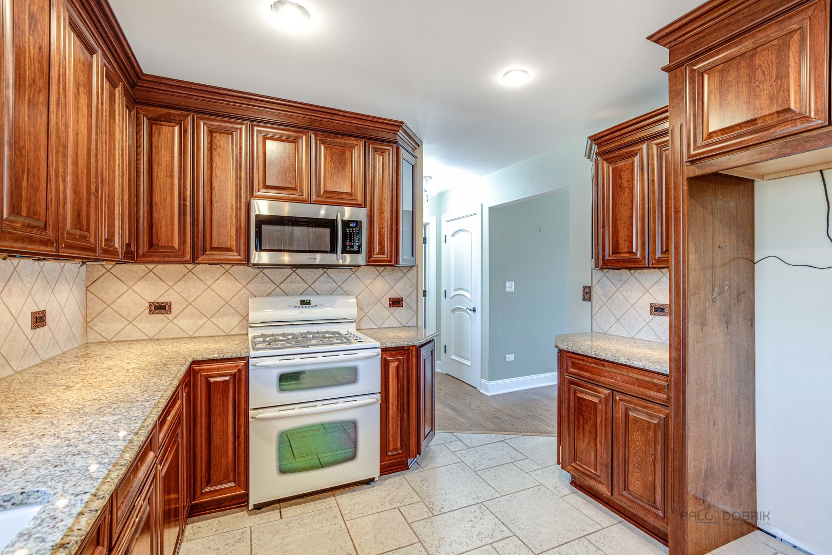 511 Alexander Boulevard Elmhurst, IL 60126 - Photo 11 of 38 a kitchen with stainless steel appliances granite countertop a stove a sink and a microwave