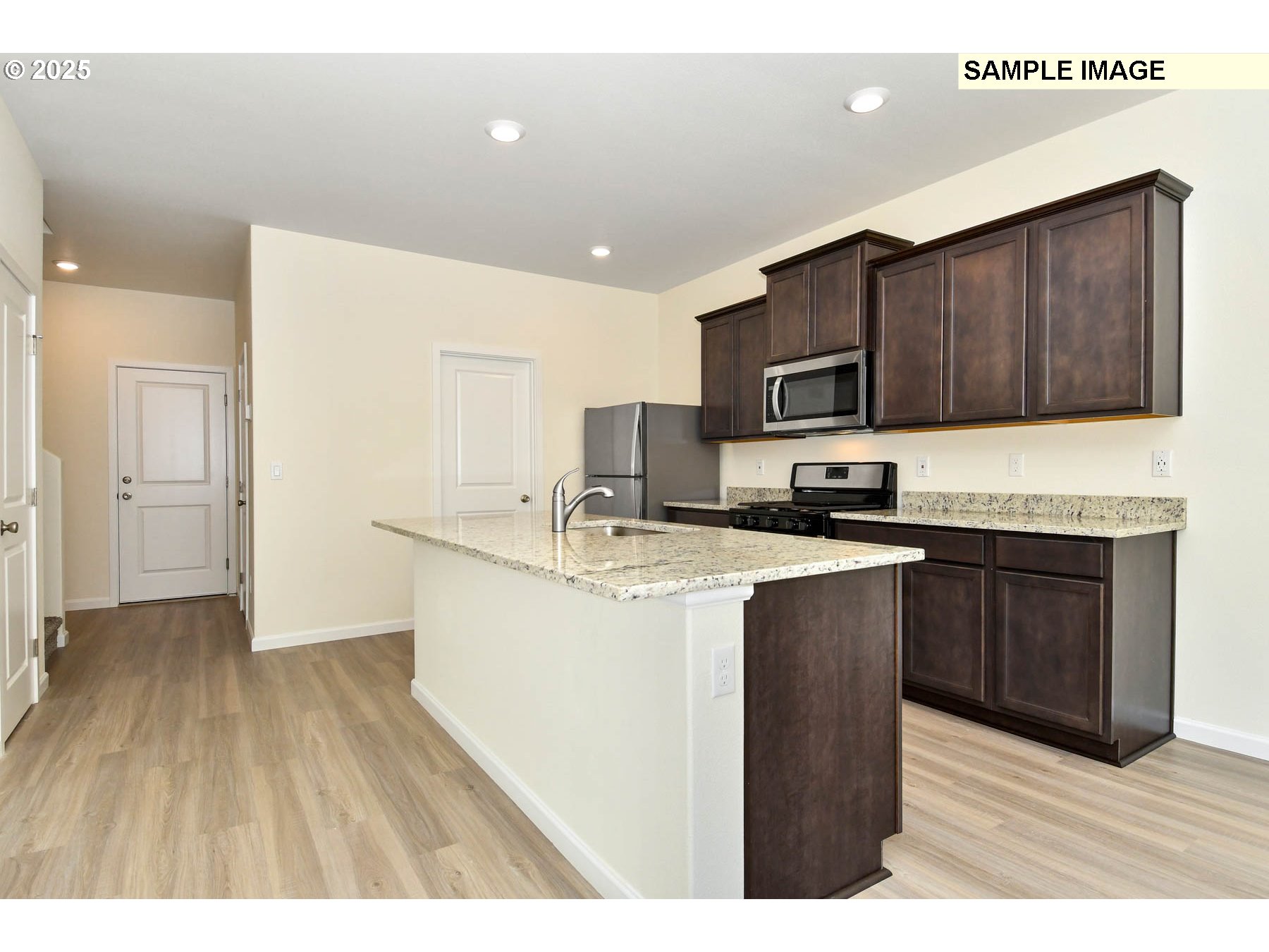 3982 Southwest Duniway Lane Gresham, OR 97080 - Photo 12 of 15 a kitchen with stainless steel appliances granite countertop a stove top oven a sink dishwasher and a refrigerator with wooden floor