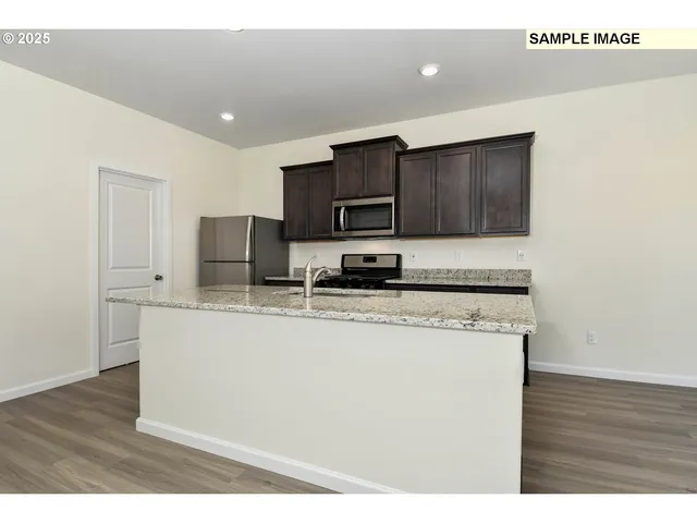 a kitchen with stainless steel appliances granite countertop a stove a sink and a microwave