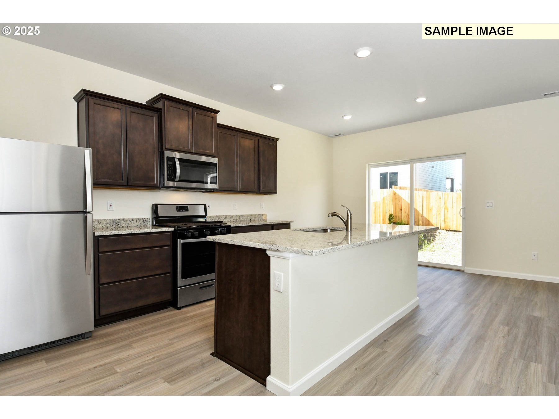 3982 Southwest Duniway Lane Gresham, OR 97080 - Photo 14 of 15 a kitchen with kitchen island granite countertop stainless steel appliances and wooden cabinets