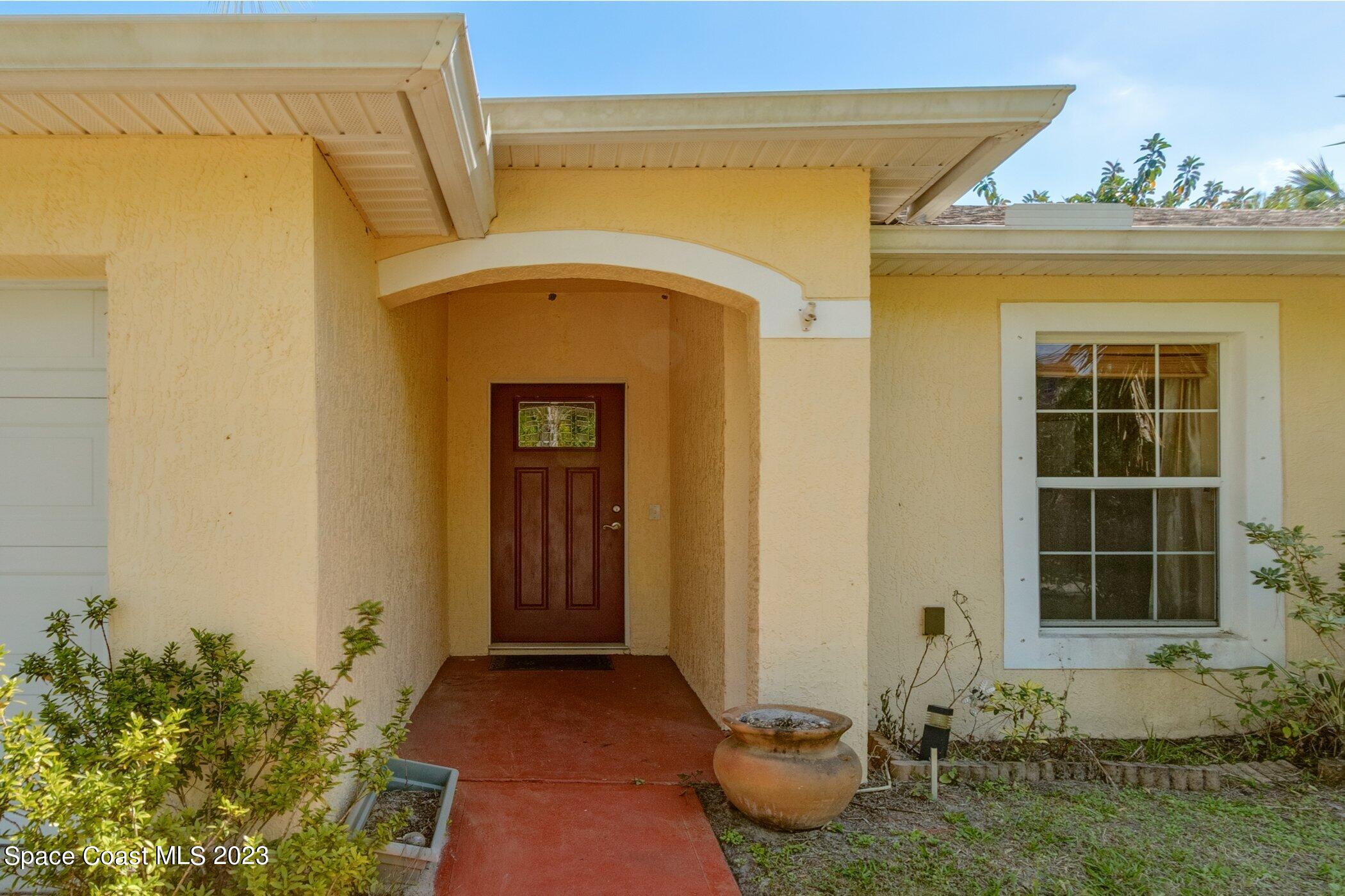 1371 Darrow Road Southwest Palm Bay, FL 32908 - Photo 1 of 21 a front view of a house with a yard