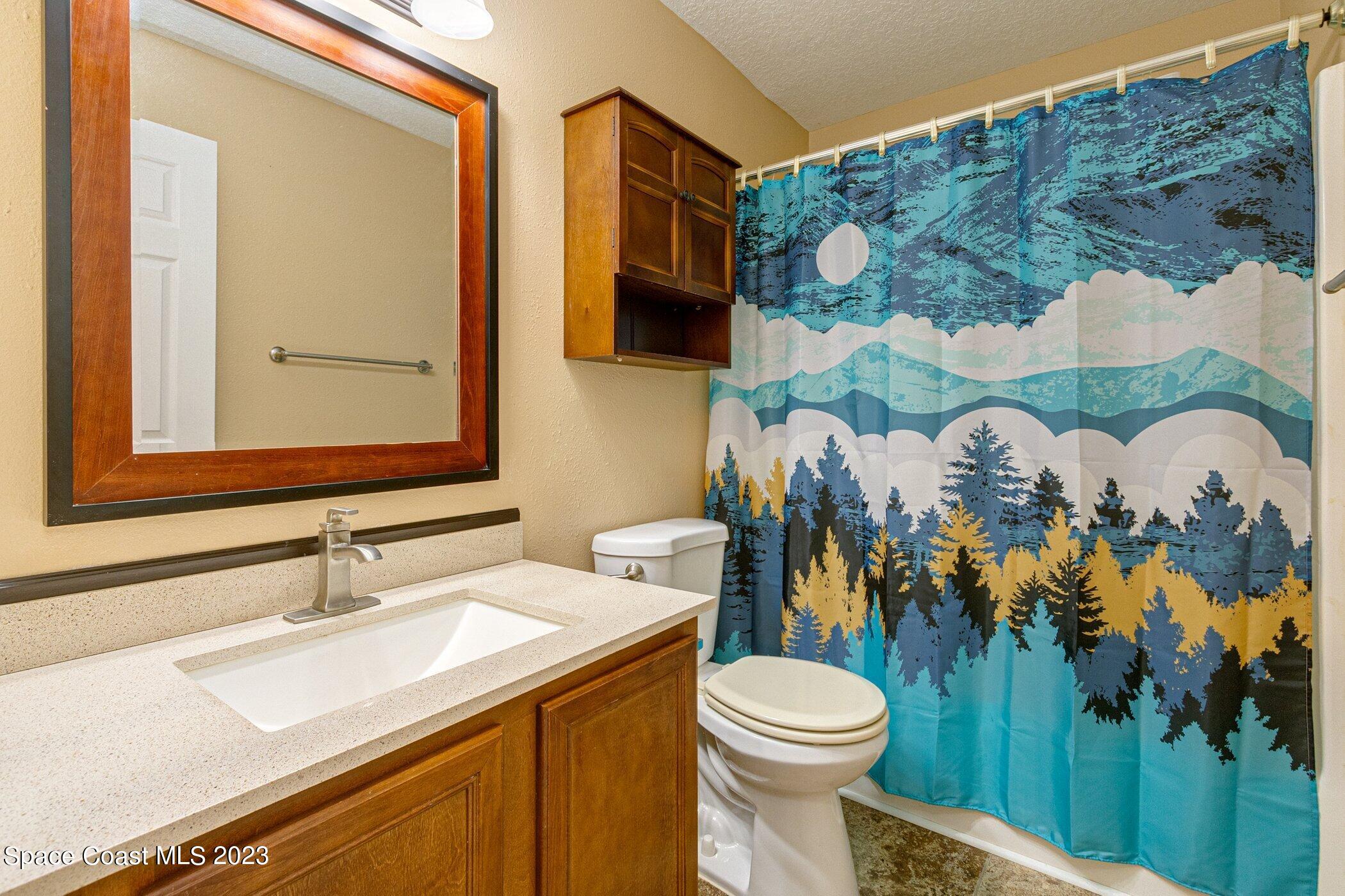 1371 Darrow Road Southwest Palm Bay, FL 32908 - Photo 17 of 21 a bathroom with a sink mirror vanity and toilet