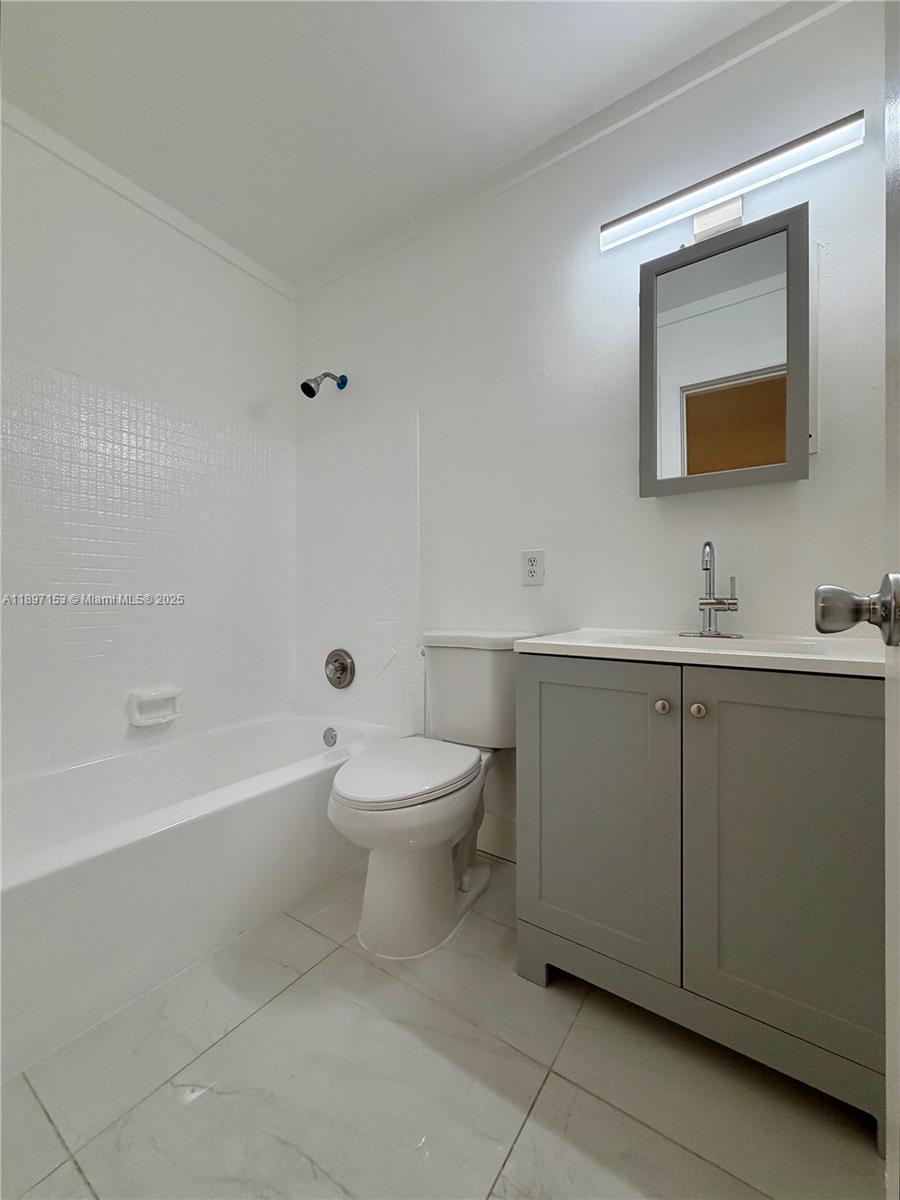 3100 Northwest 135th Street, Unit 4 Opa-Locka, FL 33054 - Photo 5 of 5 a bathroom with a toilet sink and mirror