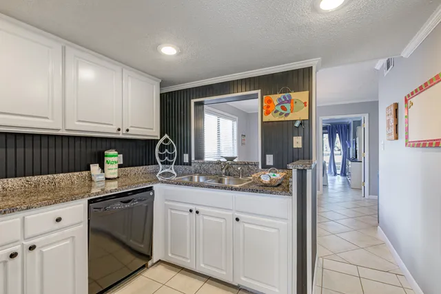 a kitchen with granite countertop a sink and cabinets