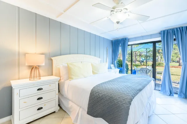 a bedroom with a bed a lamp and a large window