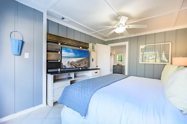 a bedroom with a large bed a chandelier and dresser
