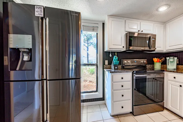 a kitchen with stainless steel appliances granite countertop a refrigerator and a stove top oven