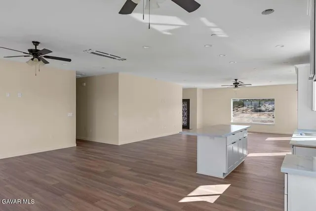 a view of a kitchen with a sink dishwasher a refrigerator and wooden floor