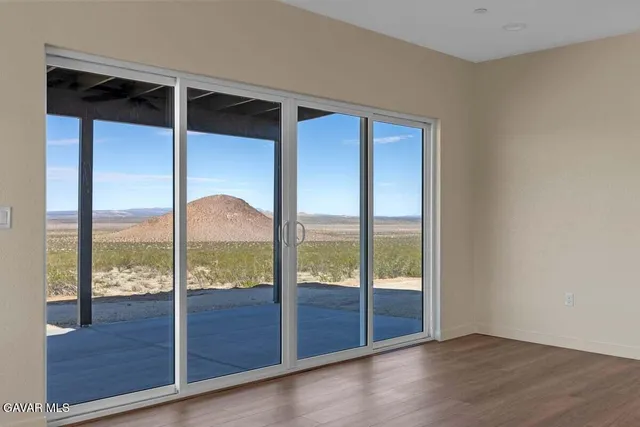 an empty room with wooden floor and sliding glass door