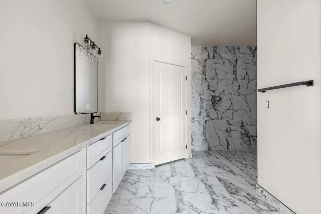 a bathroom with a granite countertop sink a shower and a mirror