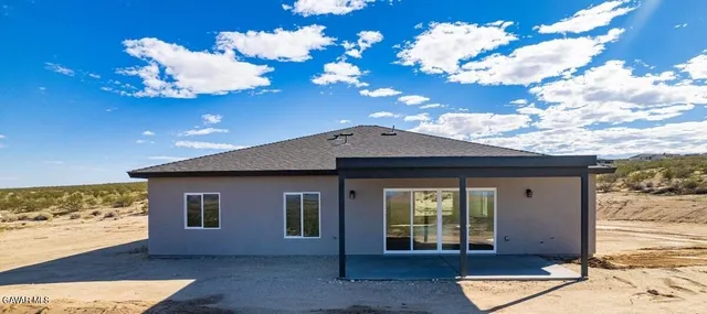 a front view of a house with a large tree