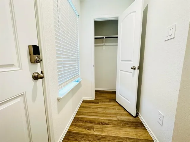 a view of a hallway with wooden floor and staircase