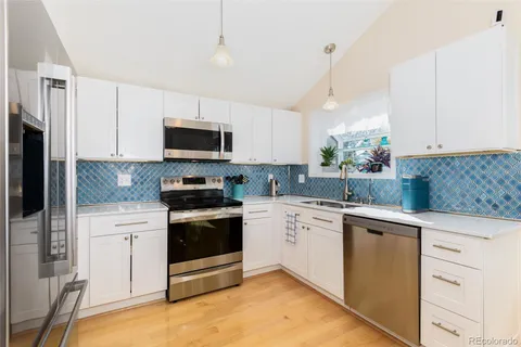 a kitchen with granite countertop a stove a sink and a microwave