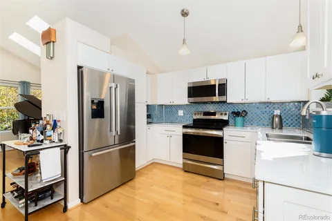 a kitchen with a refrigerator and a stove top oven