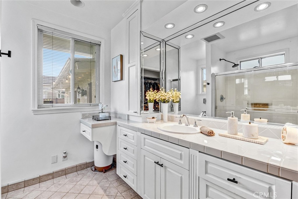 7758 Chimineas Avenue Reseda, CA 91335 - Photo 19 of 35 a bathroom with a double vanity sink a mirror and a shower