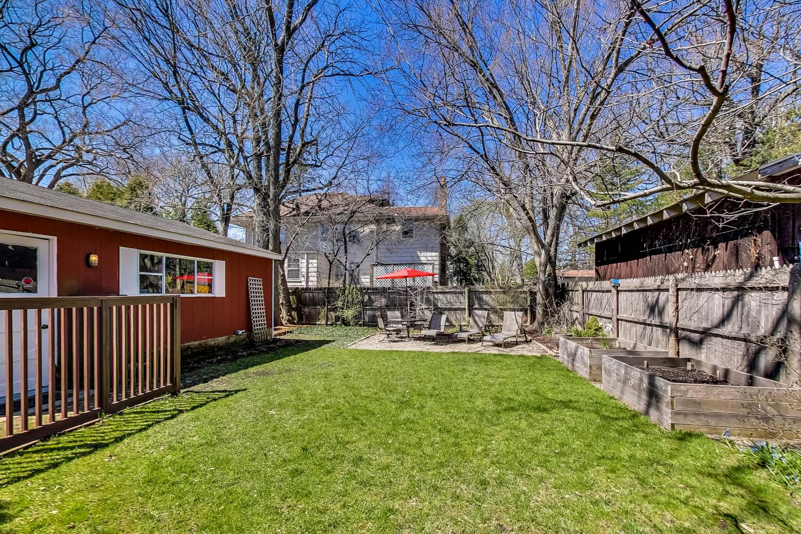 216 Myrtle Street Winnetka, IL 60093 - Photo 66 of 74 a view of a yard with table and chairs under an umbrella