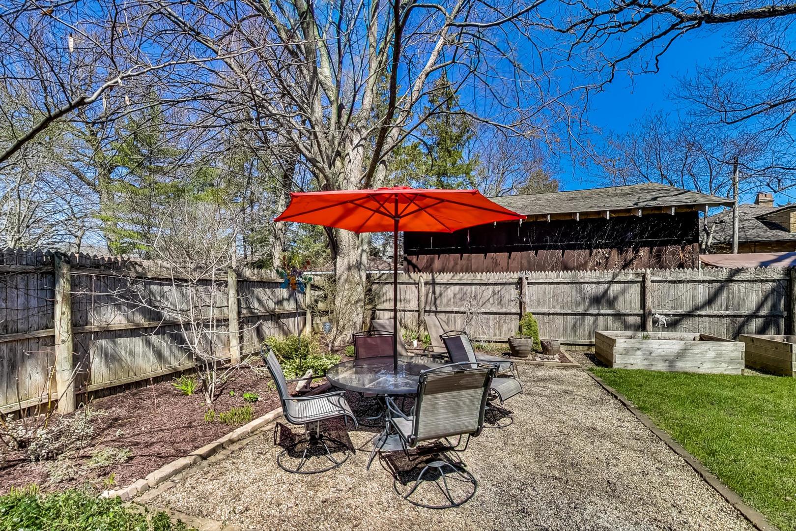 216 Myrtle Street Winnetka, IL 60093 - Photo 69 of 74 a view of a patio with table and chairs under an umbrella