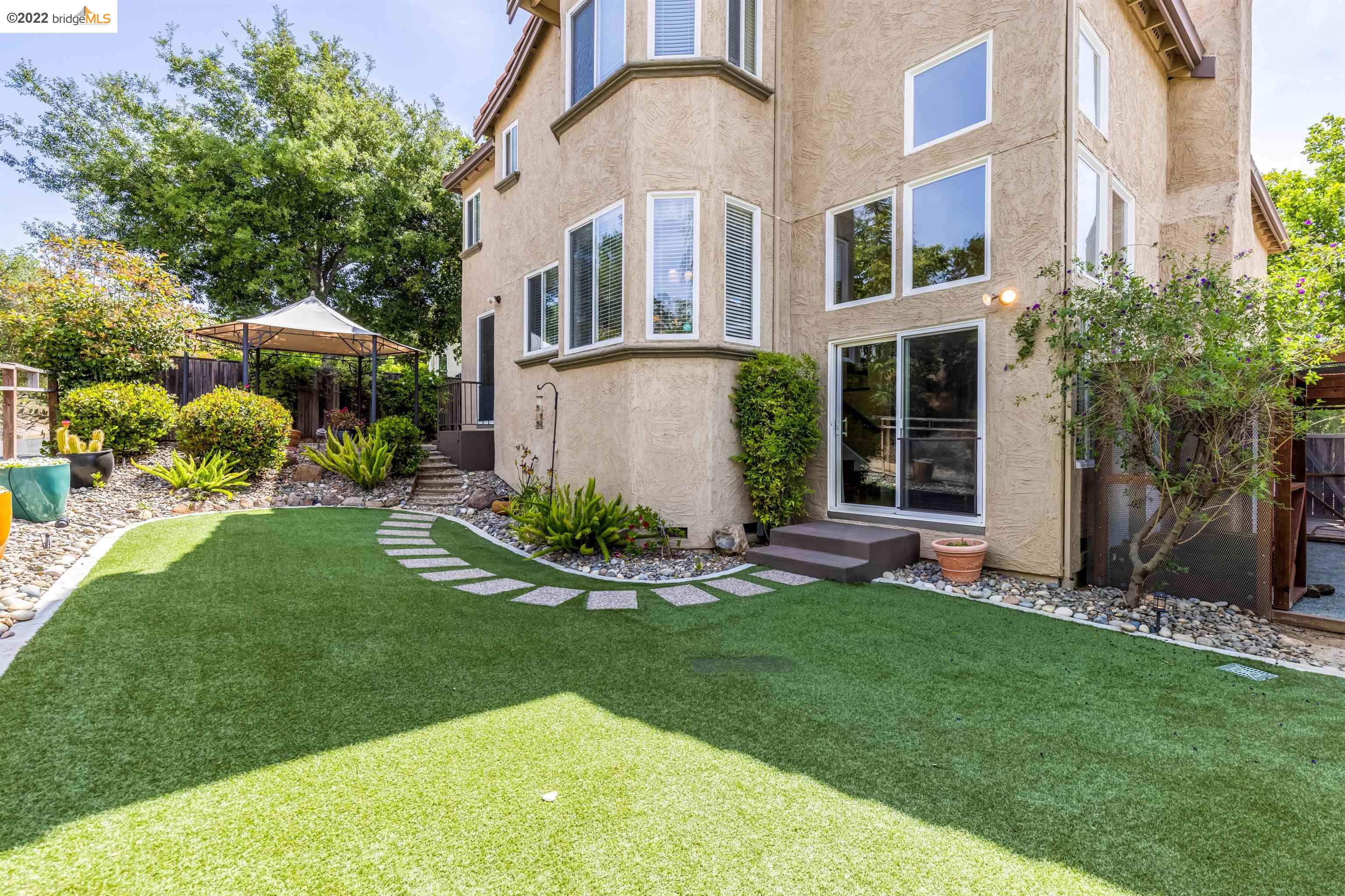Undisclosed Address Concord, CA 94521 - Photo 32 of 47 a front view of a house with a garden and plants