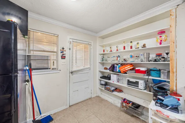 a bedroom with a bed a chandelier and a window