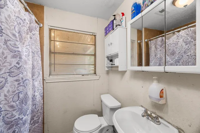 a bedroom with furniture a flat screen tv and a view of living room