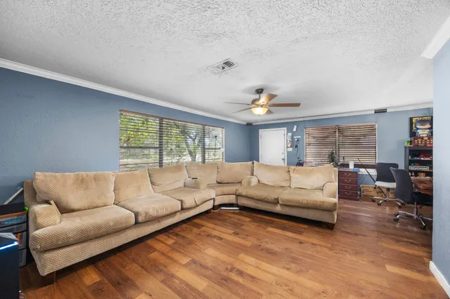 a living room with furniture a chandelier and a dining table