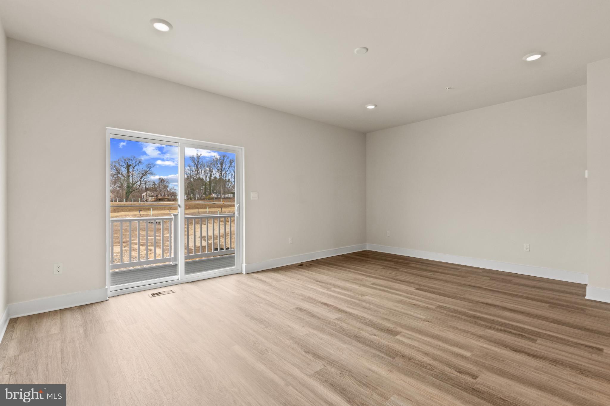 338 Hackley Drive Joppa, MD 21085 - Photo 13 of 32 an empty room with wooden floor and windows