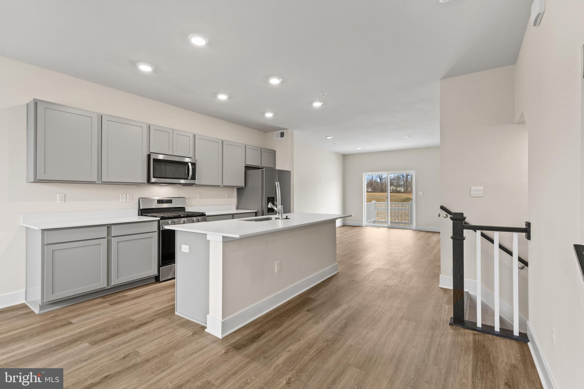 338 Hackley Drive Joppa, MD 21085 - Photo 6 of 32 a large kitchen with cabinets wooden floor and stainless steel appliances