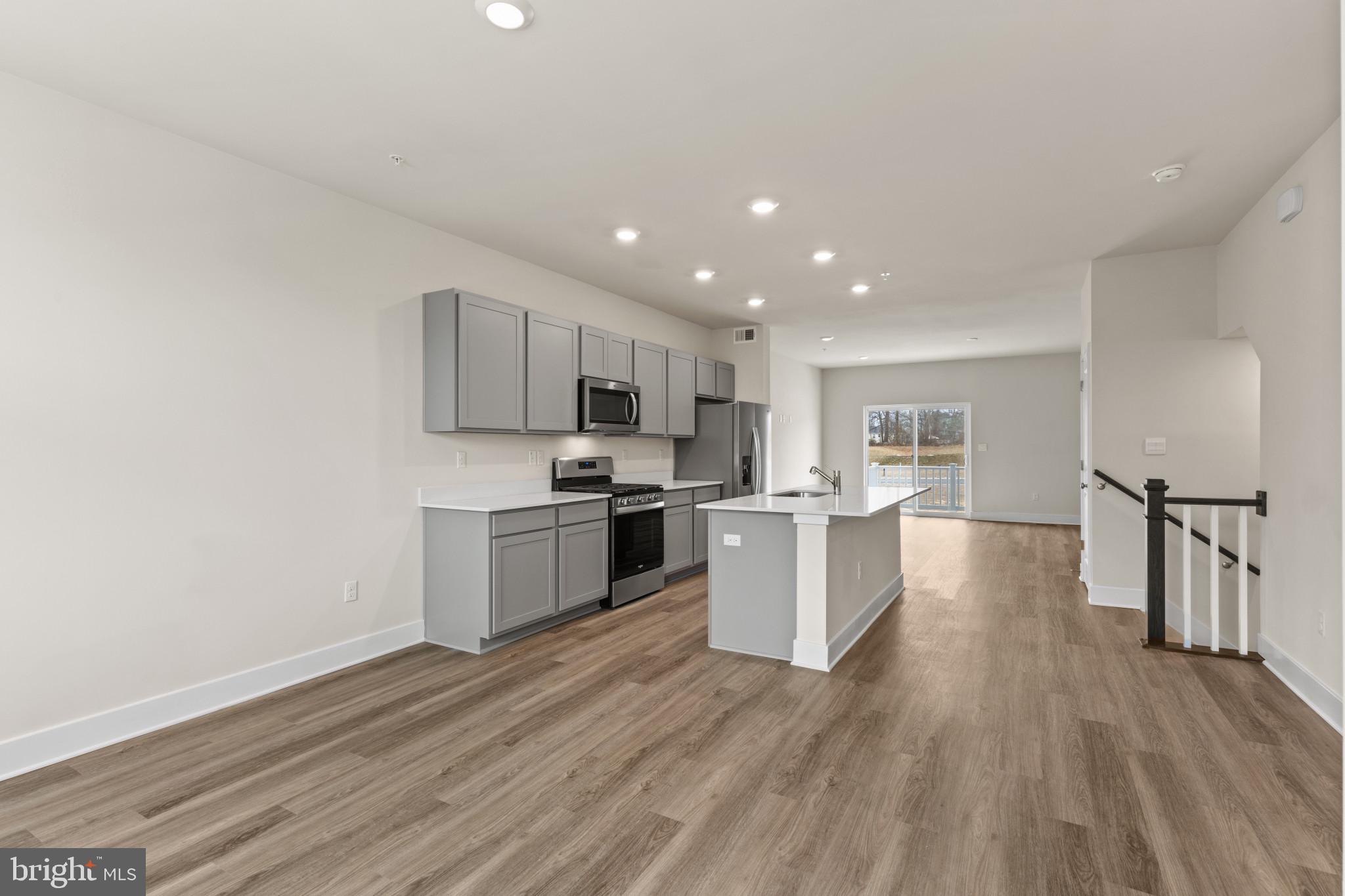 338 Hackley Drive Joppa, MD 21085 - Photo 10 of 32 a kitchen with a white cabinets and wooden floor