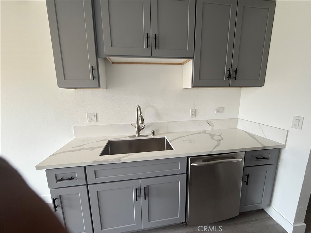 a kitchen with a sink cabinets and stainless steel appliances