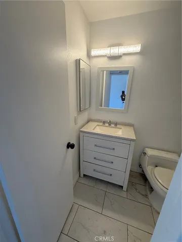 a bathroom with a sink a toilet and mirror