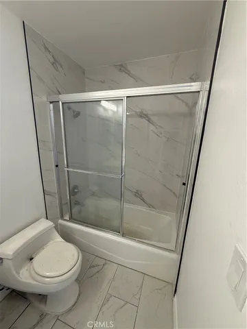 a bathroom with a toilet and a shower