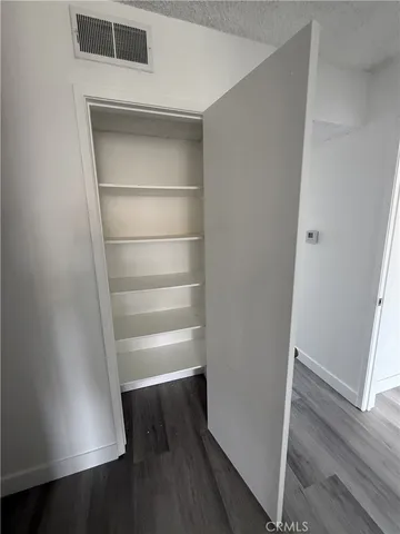 a view of walk in closet with empty racks
