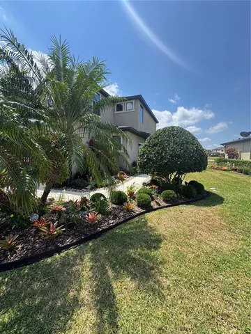 a view of a house with brick walls and a yard with plants