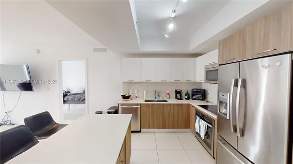 a kitchen with stainless steel appliances a refrigerator sink and microwave