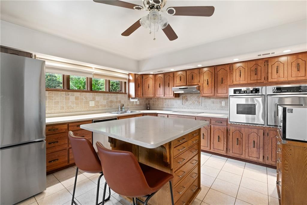 500 Allenby Avenue Pittsburgh, PA 15218 - Photo 3 of 35 a kitchen with stainless steel appliances granite countertop a sink a stove a refrigerator cabinets and a dining table