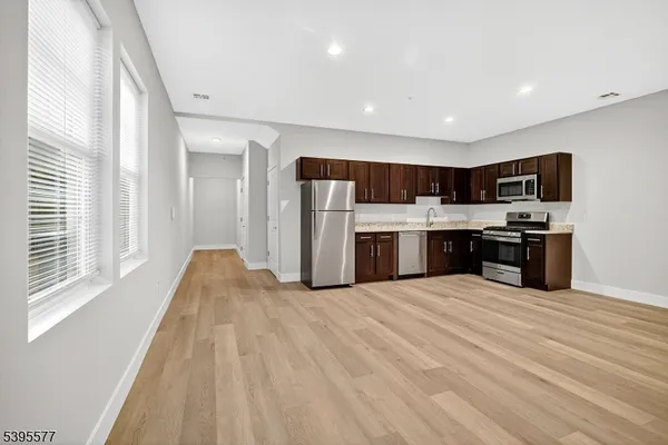 a large kitchen with a stove a sink dishwasher and a refrigerator