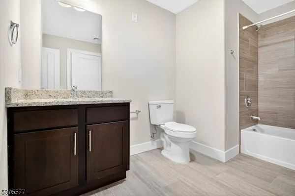 a bathroom with a granite countertop toilet a sink and a bathtub