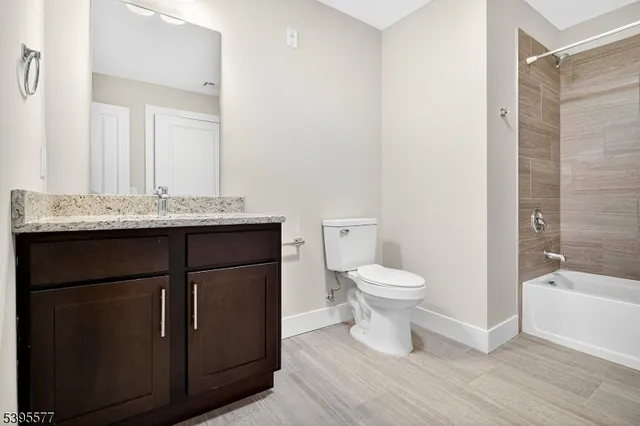 a bathroom with a granite countertop toilet a sink and a bathtub