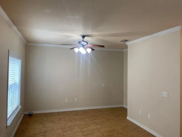 an empty room with a chandelier fan