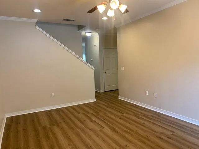 a view of an empty room with wooden floor