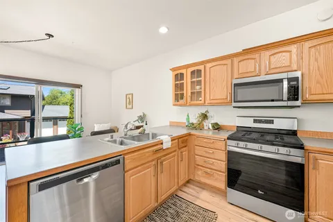 a kitchen with stainless steel appliances a stove sink microwave and cabinets